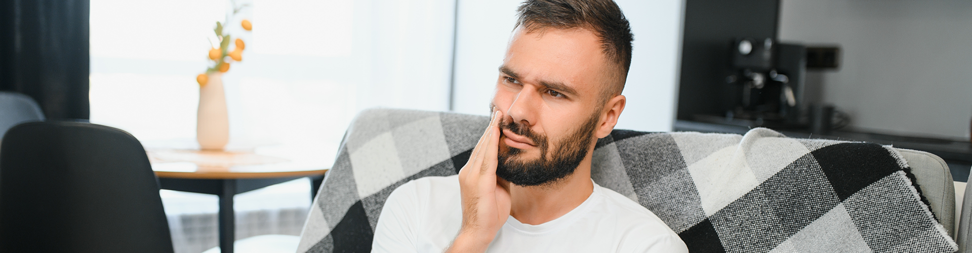 man holding his cheek in pain